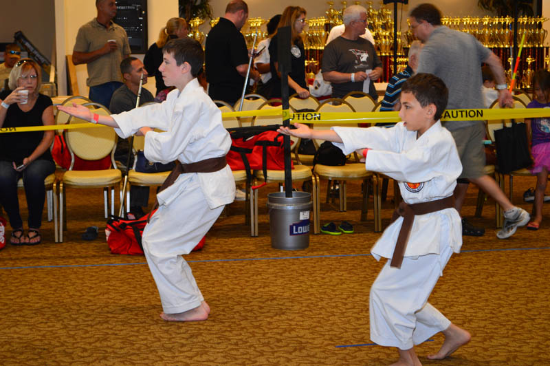 two boys where uniforms with black belts in competing in a martial arts tournament