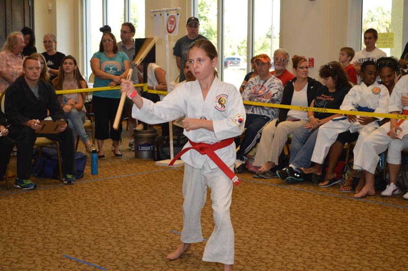 young girl with nunchucks performs a martial arts routine