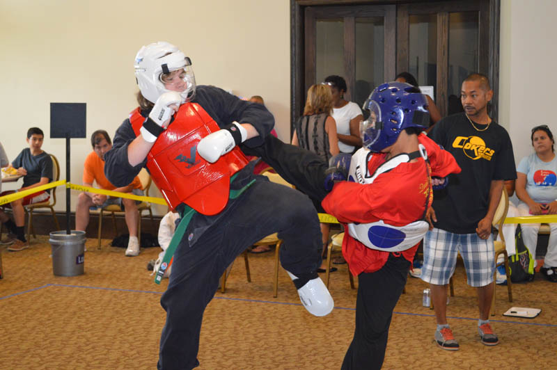 two martial artists in protective gear spar