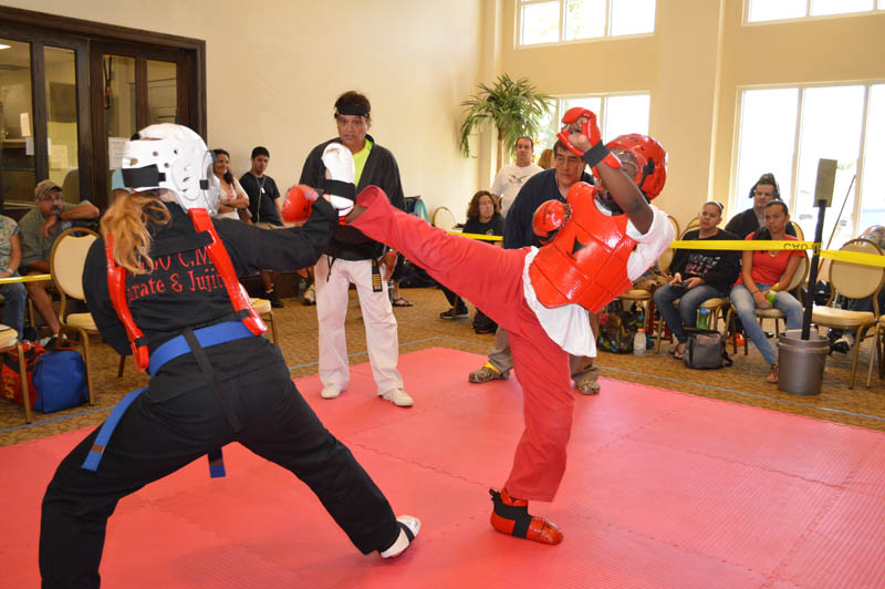 young female martial artist block kick from her sparring competitor